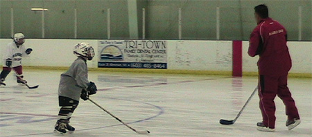 Radius Edge Power Skating program director Joe Cicolini works on backwards skating with students